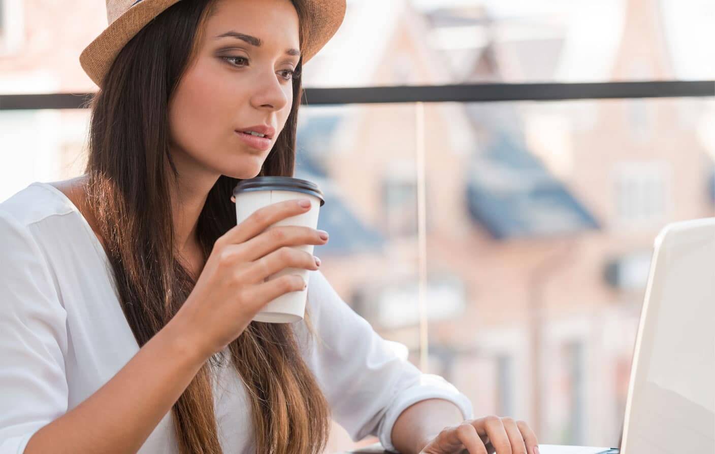 femme avec un chapeau navigue sur le site de ressources plurielles avec un café